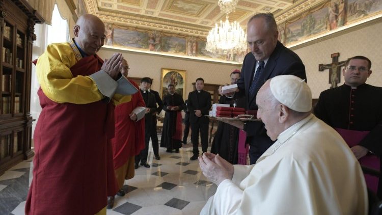 Pope Francis greets a member of the Buddhist delegation