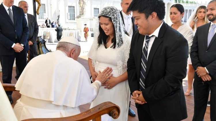 Pope Francis blesses a newly-wed pregnant woman at a General Audience
