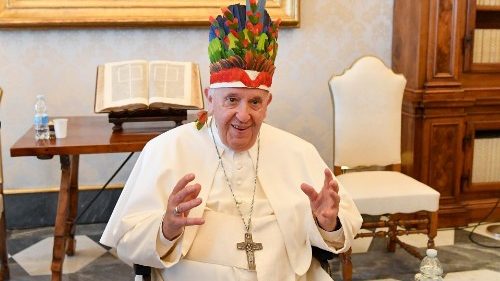 Le Pape François, recevant un groupe d'évêques du Brésil, coiffé de leur cadeau, lundi 20 juin 2022 au Vatican. 