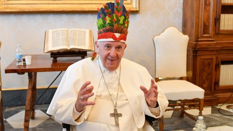 Le Pape François, recevant un groupe d'évêques du Brésil, coiffé de leur cadeau, lundi 20 juin 2022 au Vatican. 