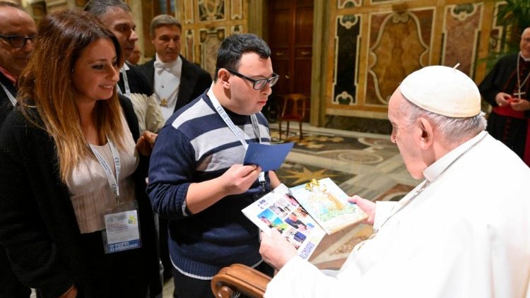 Pope Francis exchanges a greeting with a young man with a disability