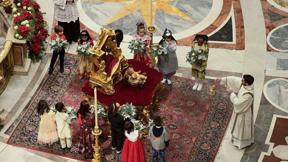 La statua di Gesù Bambino attorniata da dodici bambini da tutto il mondo che portano omaggi floreali