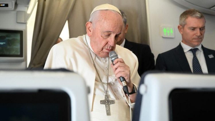 विमान में  पत्रकारों से बात करते हुए आप्रवासियों के लिए प्रार्थना करते संत पापा फ्राँसिस
