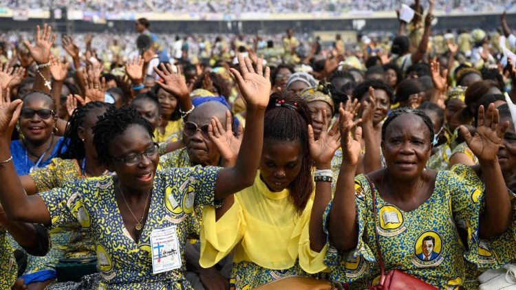 Congolese faithful hold their hands open at the Pope's invitation