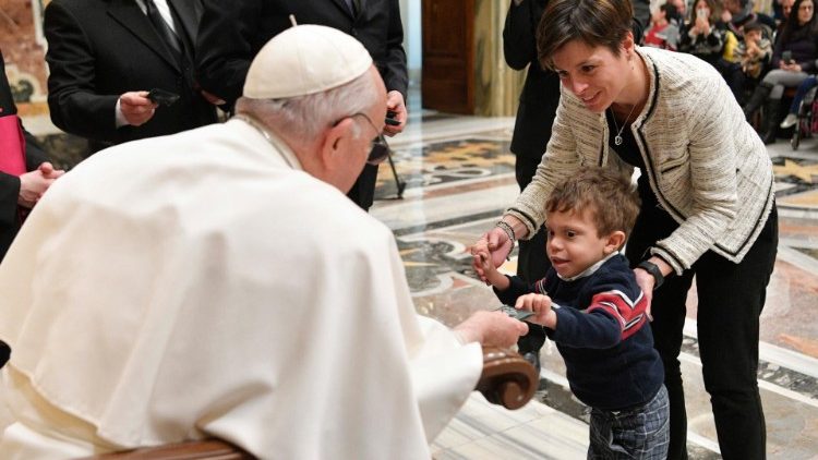 Papst Franziskus grüßt eines der Kinder mit seltenen Erkrankungen, die zur Audienz zu ihm gekommen sind