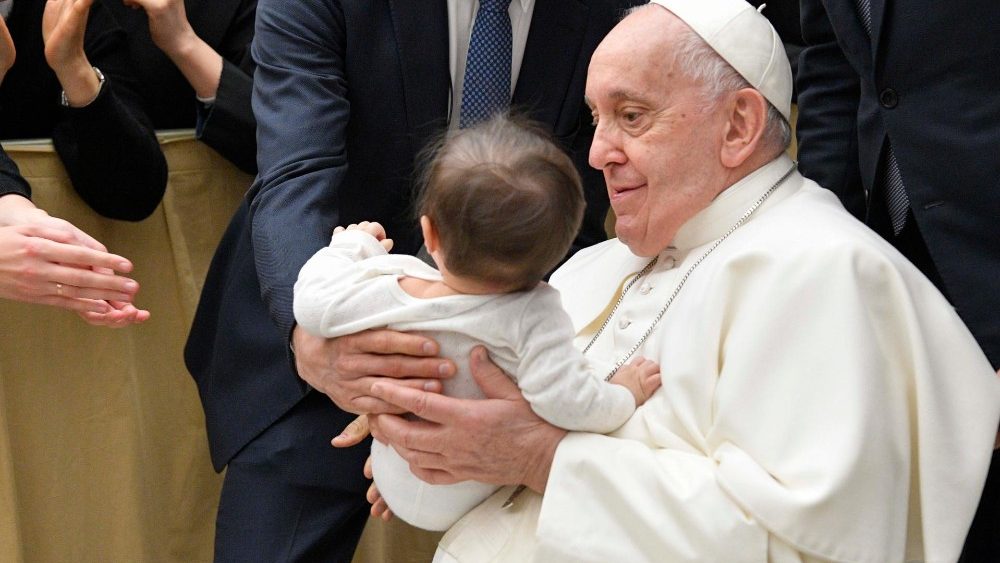 Francisco abraza a un niño