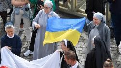 Alcuni fedeli in Piazza San Pietro per l'Angelus domenicale. Due suore con la bandiera ucraina