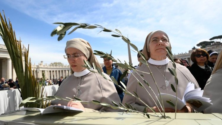 Redovnice u molitvi držeći maslinove grančice