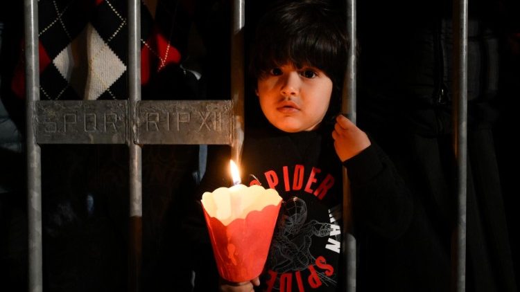 Mali dječak drži zapaljenu svijeću