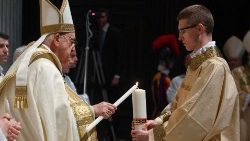Papa Francesco riceve la luce del cero pasquale portato dal diacono nella prima parte della Veglia della Notte Santa