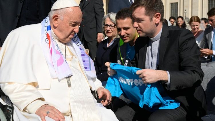 Il Papa ascolta i pellegrini e si lascia avvolgere con simboli di amicizia 