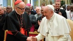 Pope Francis shakes Cardinal Czerny's hand at the audience with Caritas