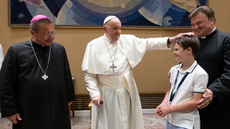 Pope Francis with a young pilgrim and Cardinal-elect Grzegorz Ryś (L)