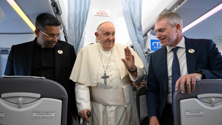 Папа Франциск на борту самолёта приветствует сопровождающих его журналистов (2 августа 2022 г.)