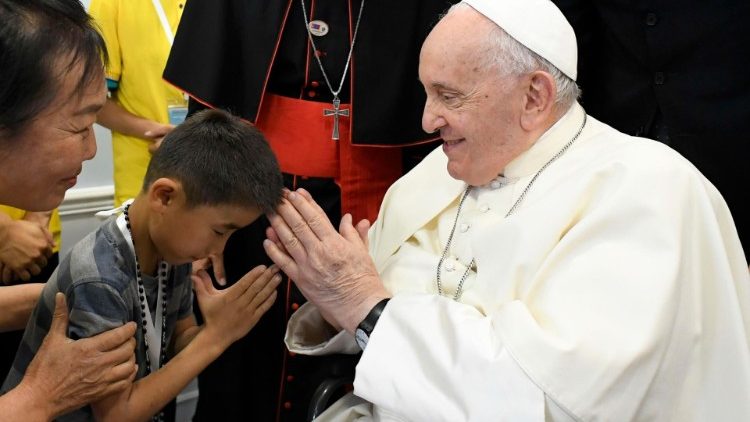 Pope Francis blesses a young boy at the "House of Mercy"