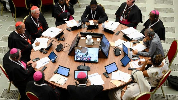 Les membres du Synode sont réunis autour de tables rondes, une nouveauté