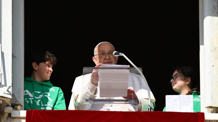 El Papa Francisco asomado desde el balcón pontificio junto a dos jóvenes de Acción Católica. 