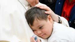 Pápež František objíma dieťa