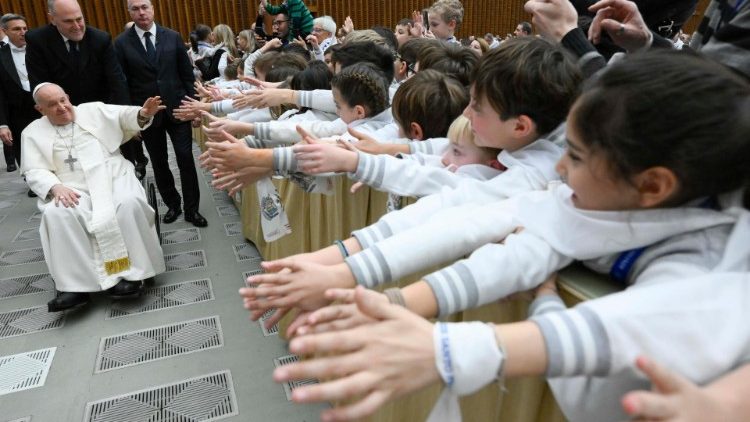 Las manos extendidas de los niños y jóvenes del Colegio Rotondi reciben al Papa en el Aula Pablo VI