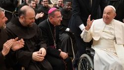 Pope Francis laughs with Franciscan friars at the audience