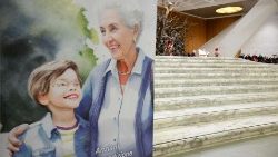 Oma mit Enkel auf einem Plakat in der vatikanischen Audienzhalle, im Hintergrund Papst Franziskus (87)