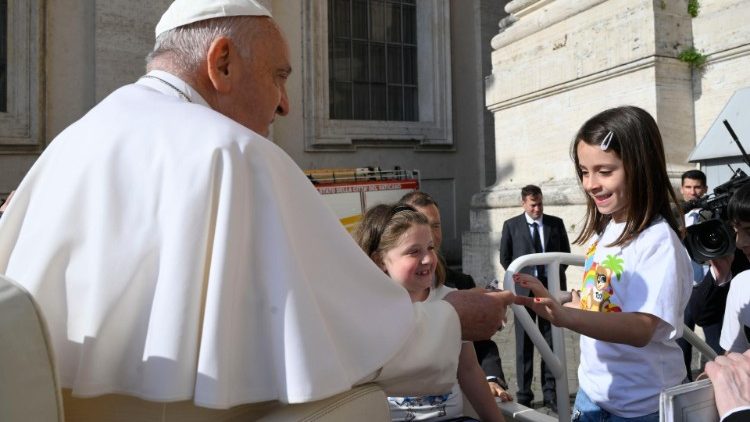 Le Pape salue une jeune fille lors de l'audience générale. 