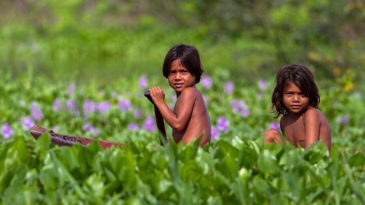 children rowing across in the rain forests of Amazonia 