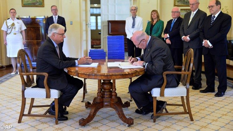 Archive photo of Commissioner Justice Peter McClellan (L)  watching  as Peter Cosgrove (R) signs a document after receiving the final Report of the Royal Commission into Institutional Responses to Child Sexual Abuse