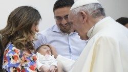 O Papa Francisco saudando uma família