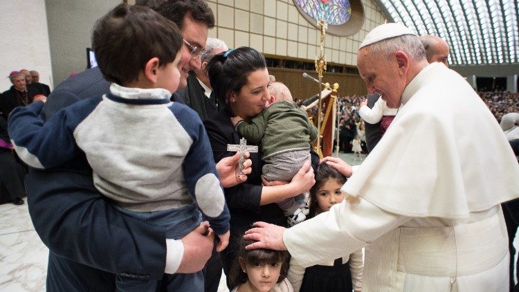 Pope Francis meets with a family during an audience in the Paul VI Hall