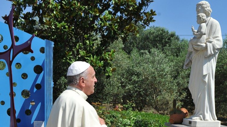 Pope Francis prays before a statue of St. Joseph