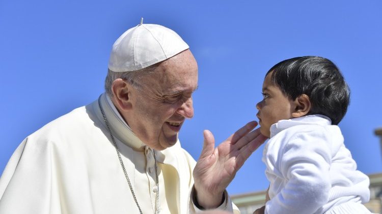 Ferenc pápa megáld egy kisgyermeket