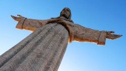 Mit ausgebreiteten Armen wendet sich die Figur des Christus König der Ponte 25 de Abril und der Stadt Lissabon zu.