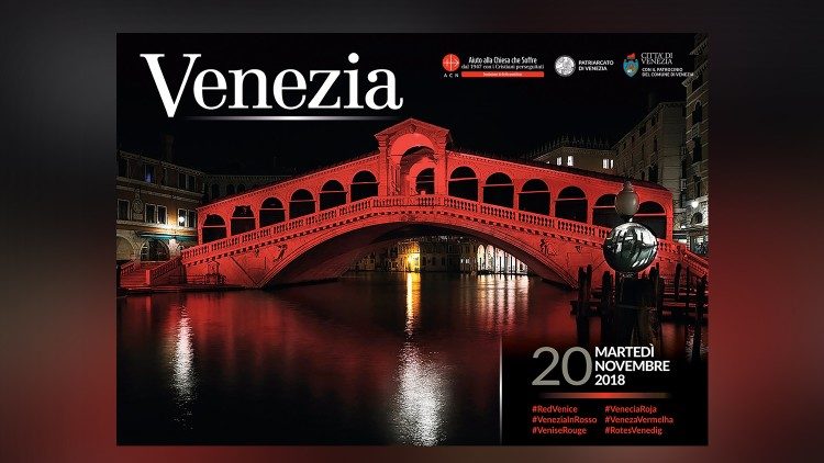 The Rialto Bridge of Venice lit up in red. 