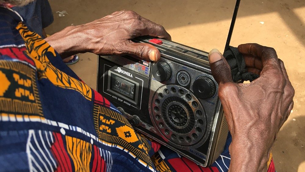 En África, un hombre escucha la radio con un viejo aparato.