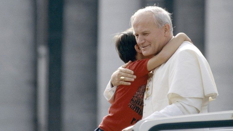 Le Pape Jean-Paul II serre un enfant dans ses bras lors d'une audience générale place Saint-Pierre de Rome. 