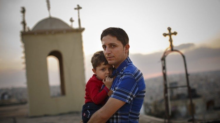 Un padre con suo figlio nei pressi della chiesa caldea di Mar Polus, San Paolo a Mosul