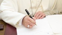 Papa Francisc semnând un document.