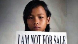 Una niña con un cartel que dice: "Yo no estoy a la venta".