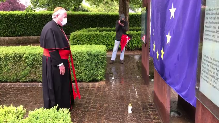 Cardinal Jean-Claude Hollerich prays before the EU flag in Schengen