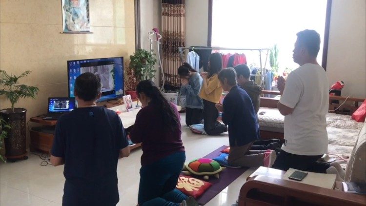Chinese Catholics kneel in prayer as they follow a live-streamed Mass celebrated by Pope Francis in Casa Santa Marta.