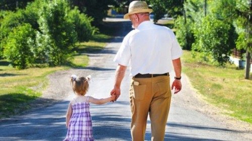 A young girl takes a walk with her grandfather