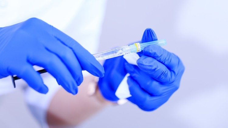 A nurse with gloves prepares an injection