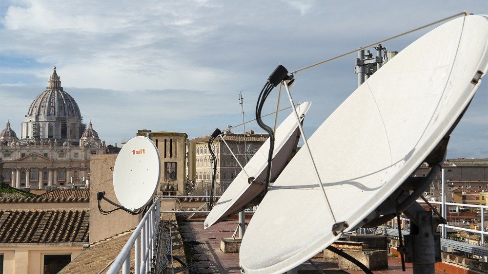Satellite dishes on the roof of the headquarters of Vatican Radio, with St Peter's in the background