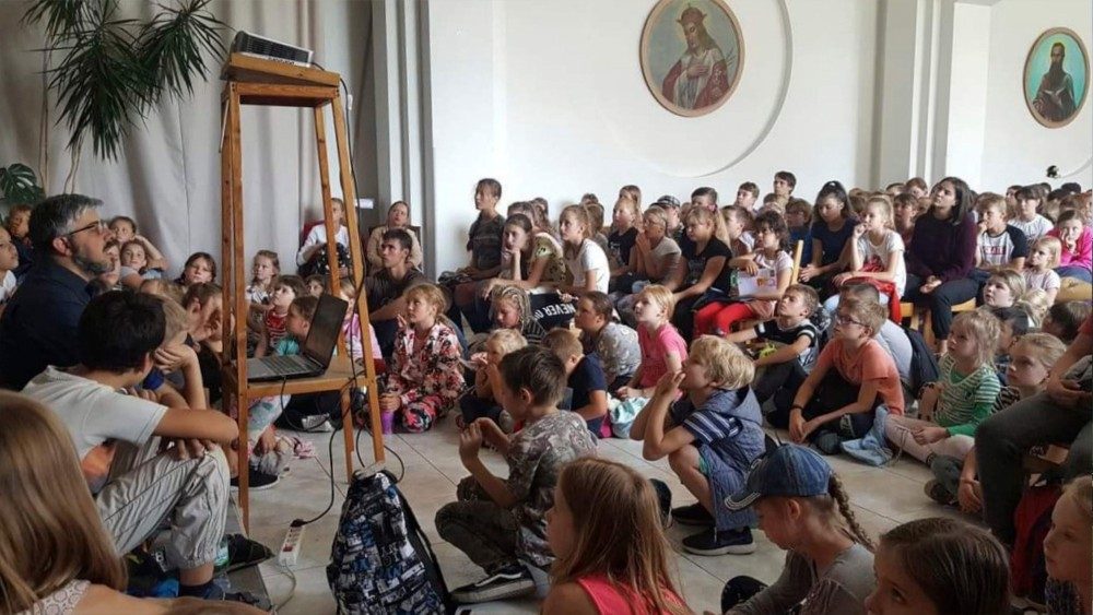 Missione salesiana in Lituania, un sacerdote insegna ai bambini i fondamenti della fede