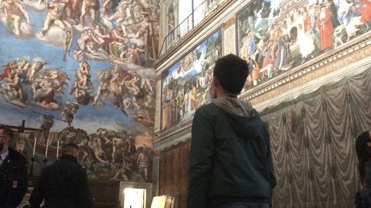 A visitor stands in front of the Sistine Chapel