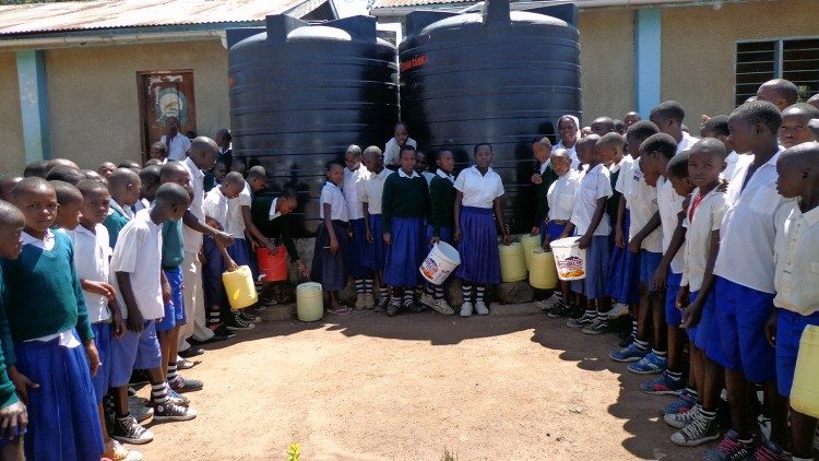 Estudiantes de Masanga junto a los depósitos de agua