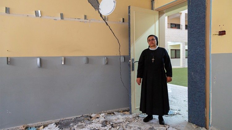 Sister Nabila surveys damage inside the Holy Family parish compound