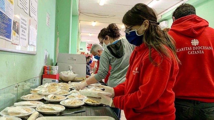 Des volontaires de la Caritas italienne préparent des repas pour des personnes dans le besoin. 