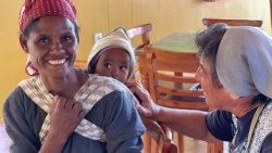 Une religieuse missionnaire en Éthiopie en conversation avec une femme et sa fille.